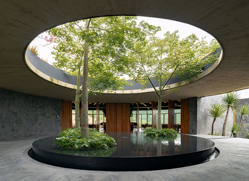 curved stone pavilion encloses circular reflecting pool for clubhouse in mexico