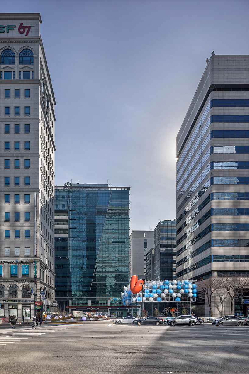 vibrant balloons nestle within metallic scaffolding atop seoul's playful urban hub by SSP