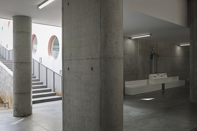circular colored openings pierce through concrete facade of school extension in lebanon