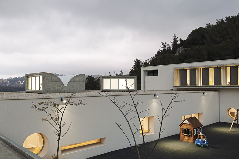 circular colored openings pierce through concrete facade of school extension in lebanon