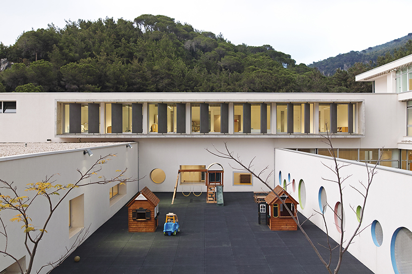 circular colored openings pierce through concrete facade of school extension in lebanon