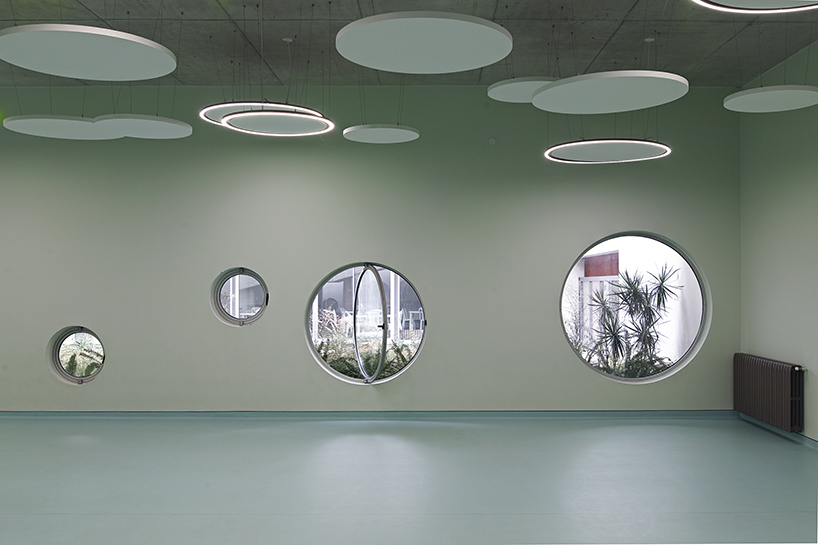 circular colored openings pierce through concrete facade of school extension in lebanon