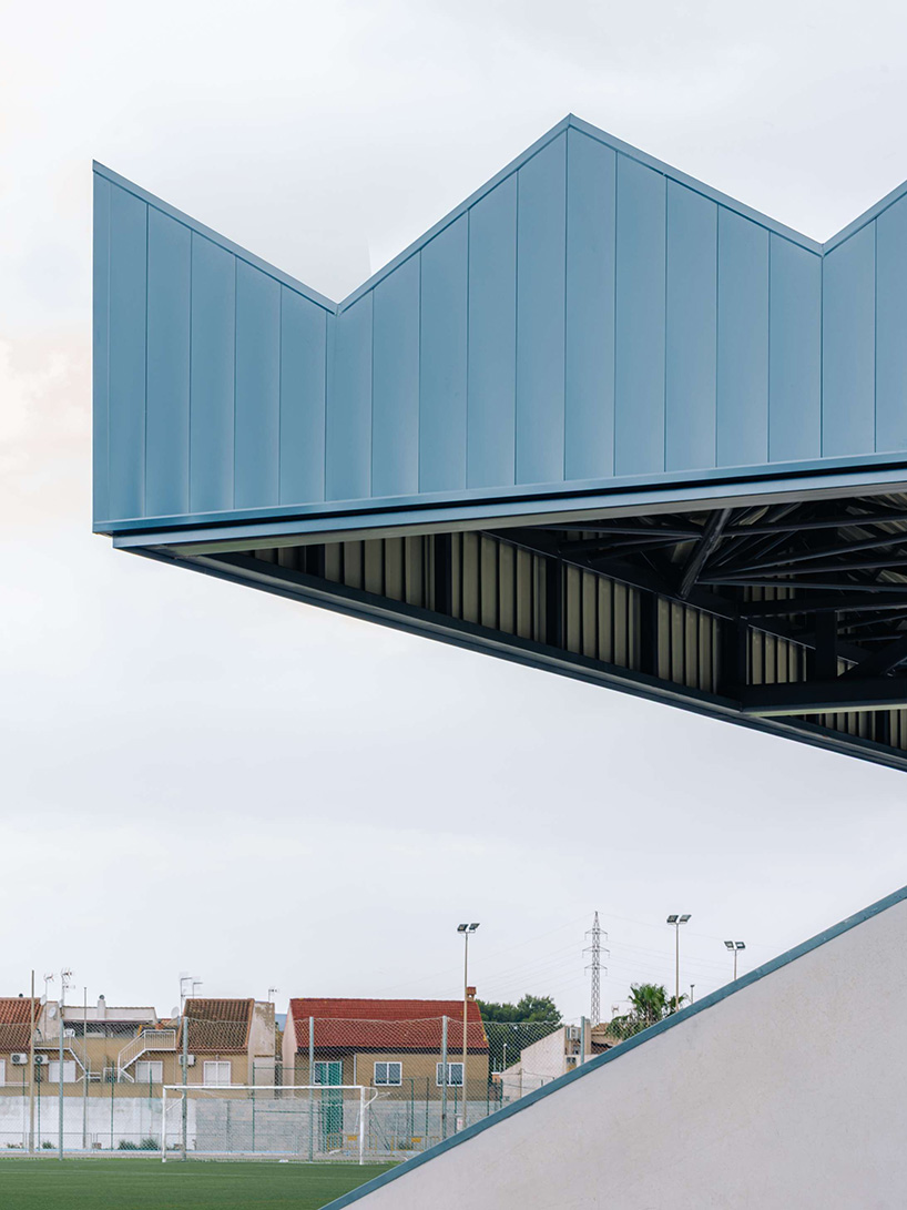 ribbed lime-green gateway and blue solar canopy reform municipal sports center in spain - 6