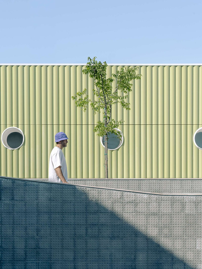 ribbed lime-green gateway and blue solar canopy reform municipal sports center in spain - 3