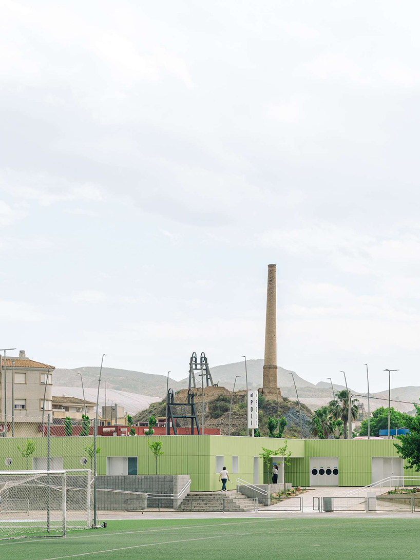 ribbed lime-green gateway and blue solar canopy reform municipal sports center in spain - 1