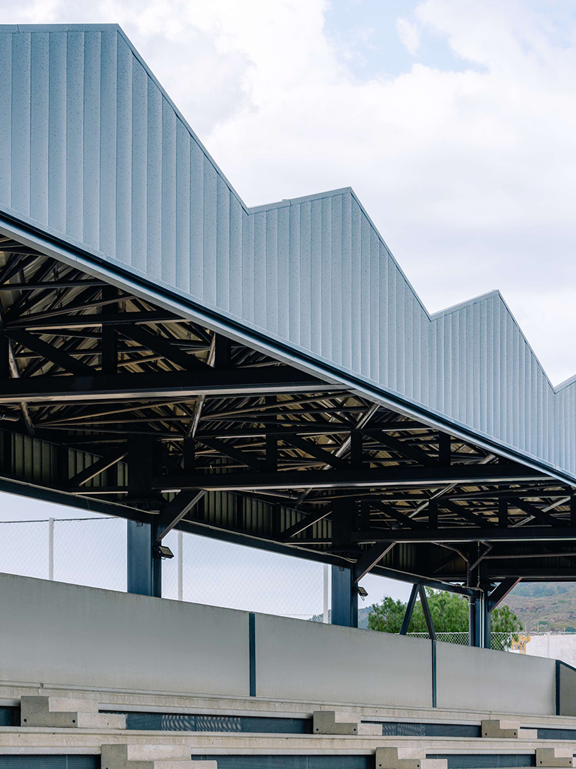 ribbed lime-green gateway and blue solar canopy reform municipal sports center in spain - 7