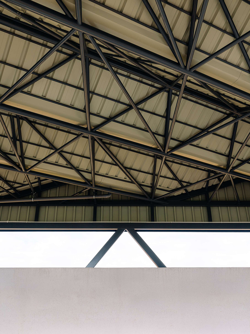 ribbed lime-green gateway and blue solar canopy reform municipal sports center in spain - 9