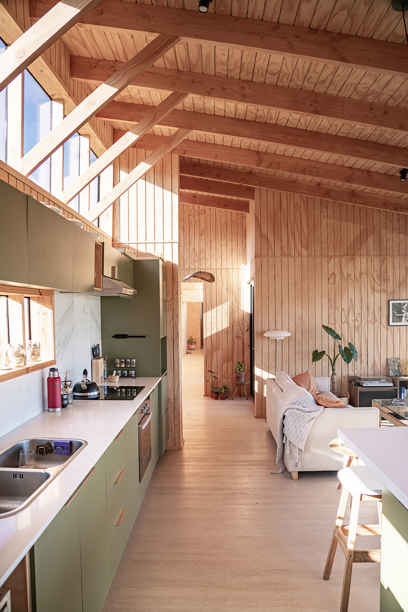 charred timber wraps linear casa las tupas, topped with pitched roof in northern chile