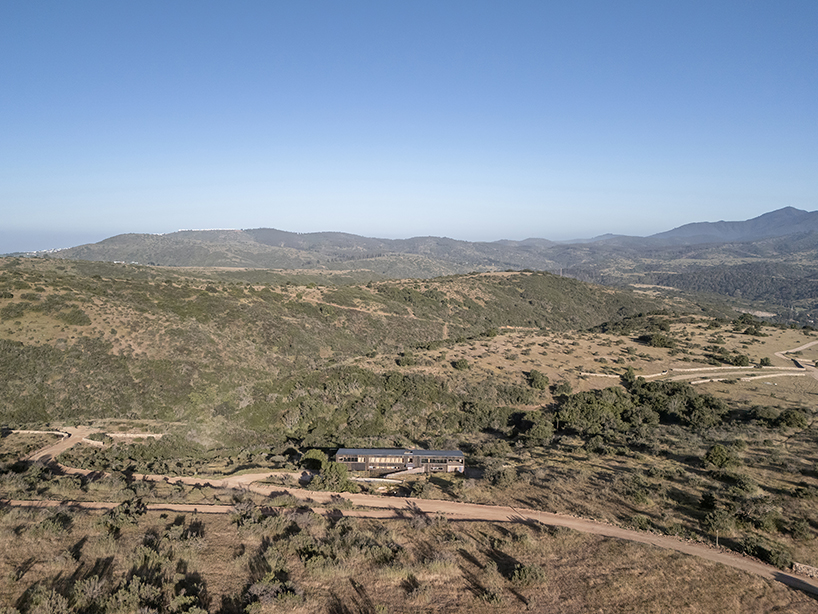 pitched roof tops linear casa las tupas, clad in charred timber in northern chile
