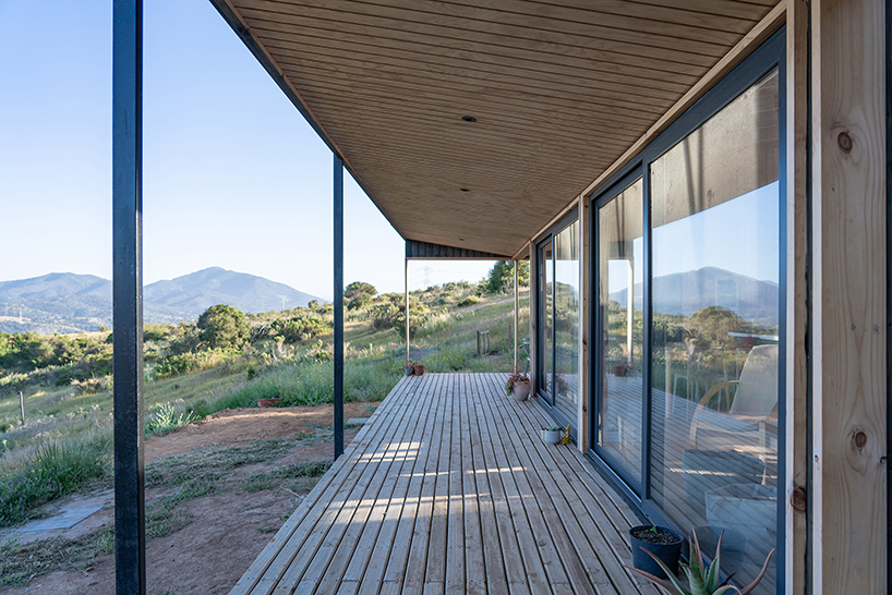 charred timber wraps linear casa las tupas, topped with pitched roof in northern chile