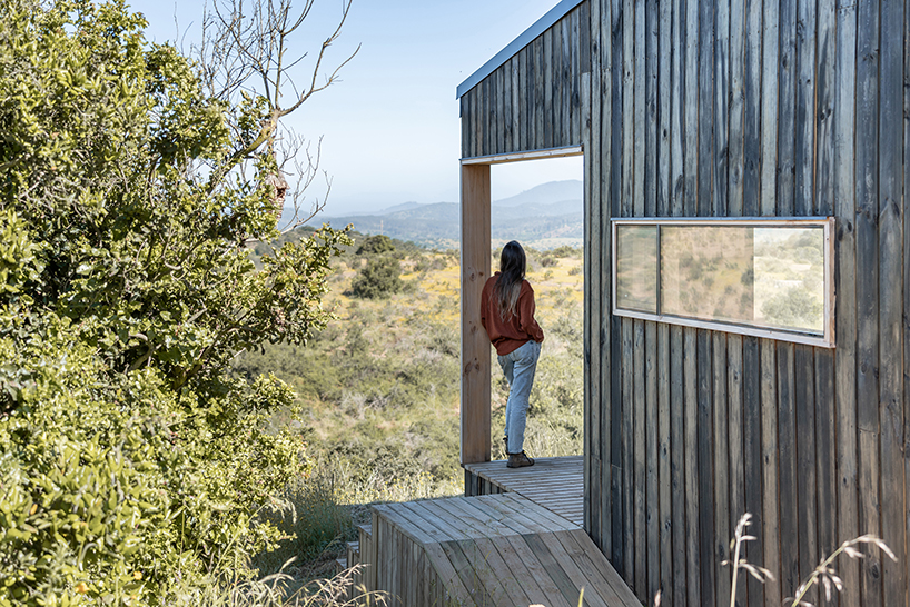 charred timber wraps linear casa las tupas, topped with pitched roof in northern chile