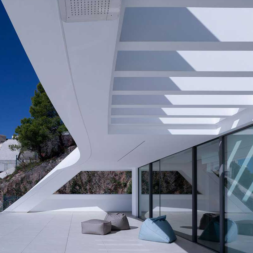curved house's sinuous facade traces mountainous terrain in spain