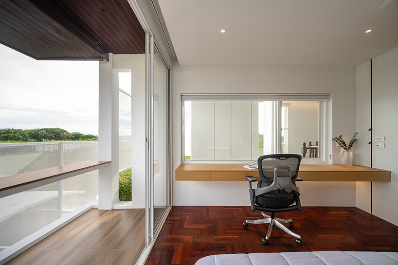 curved textile facades wrap reborn house in bangkok village emitting soft glow