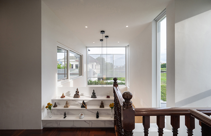 curved textile facades wrap reborn house in bangkok village emitting soft glow