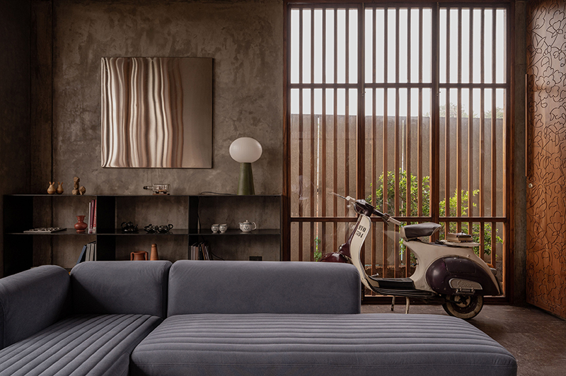 hybrid office-residence extends raw concrete balcony above recessed timber mass in india