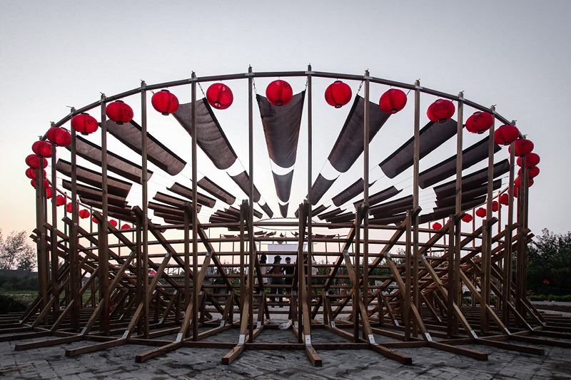 ladders turn into circular framework for climbing amphitheater in rural chinese town
