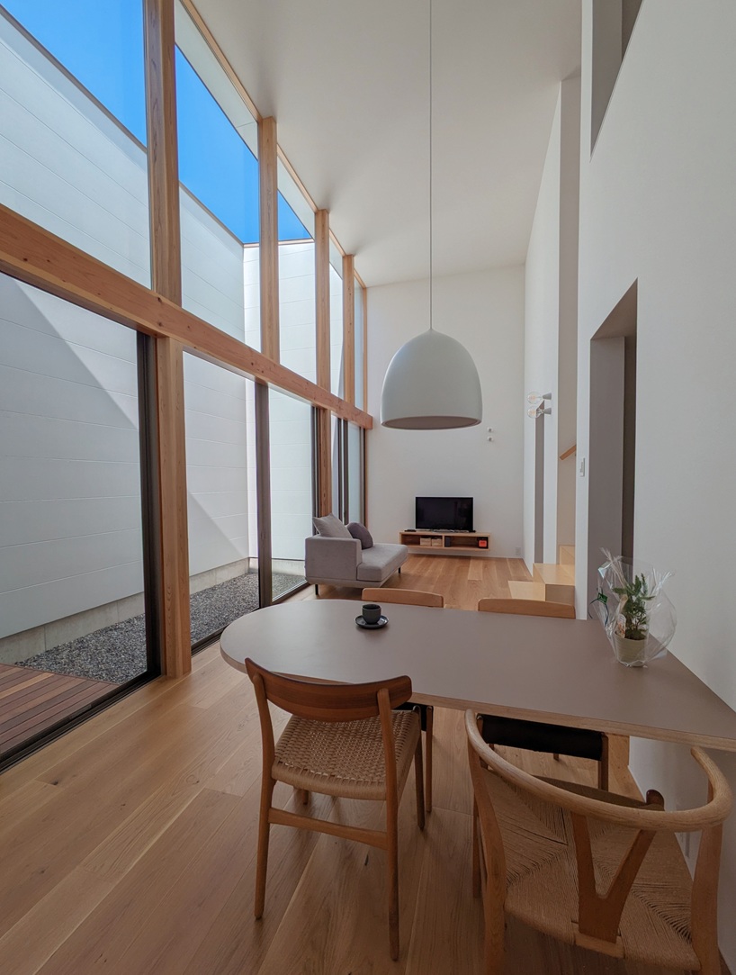wooden facade parts like a curtain revealing japanese residence's sunlit interiors