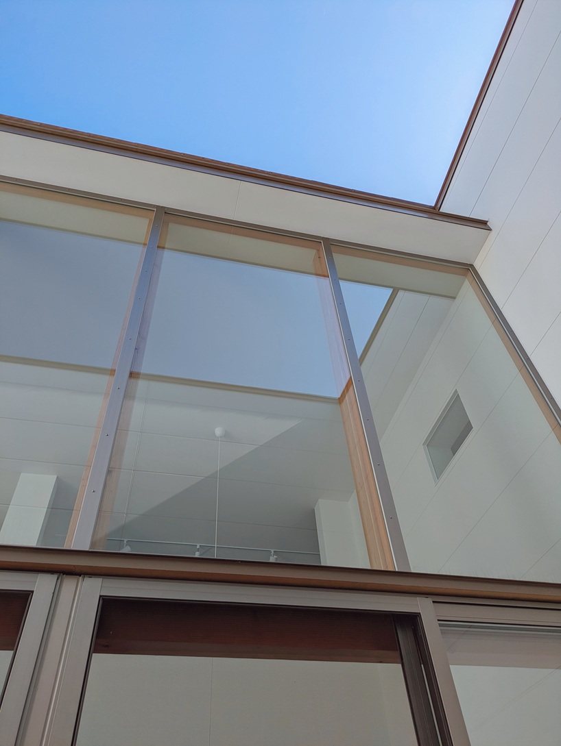 wooden facade parts like a curtain revealing japanese residence's sunlit interiors