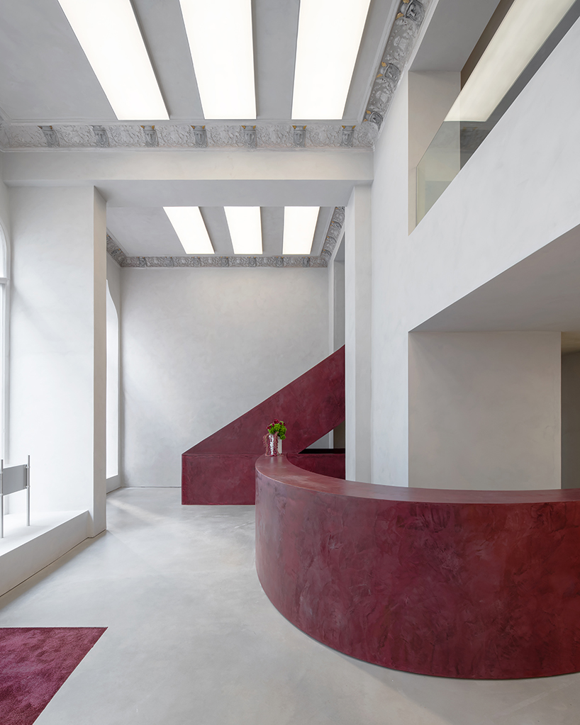 parabolic structures painted in burgundy stucco outline stockholm flagship for chimi eyewear