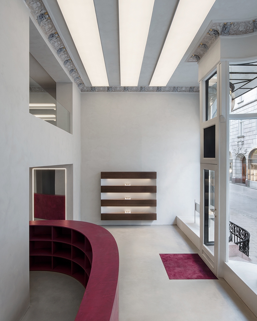 parabolic structures painted in burgundy stucco outline stockholm flagship for chimi eyewear