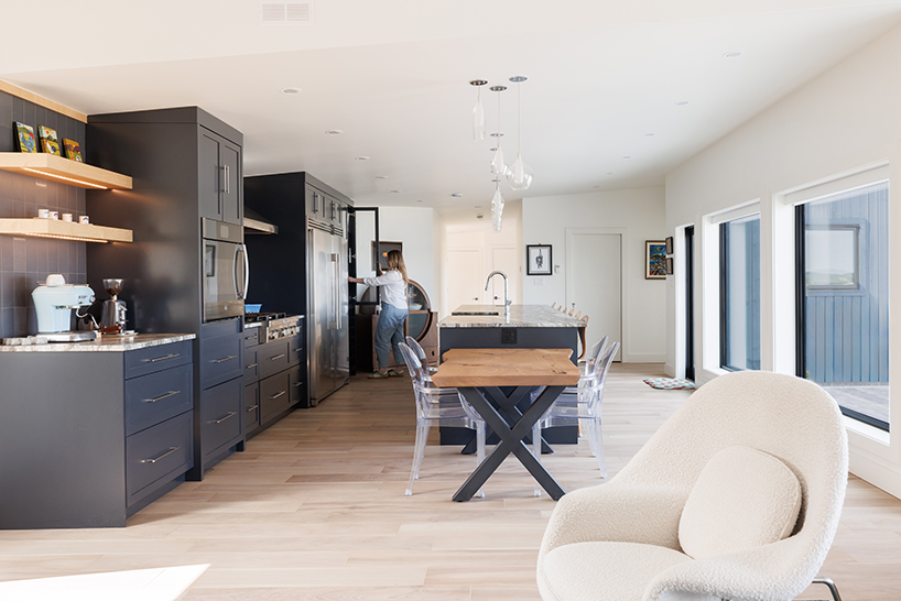 contrasting gable and mono-pitched metal roofs top wooden coley's point house in canada
