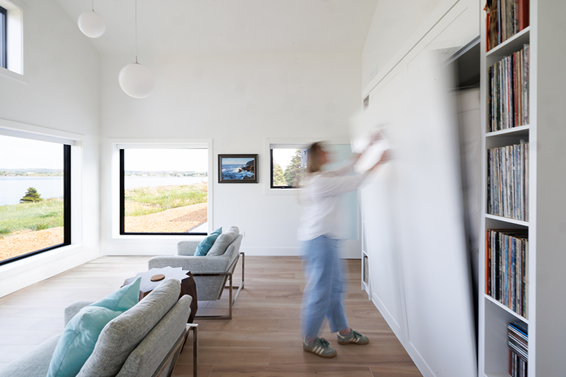 contrasting gable and mono-pitched metal roofs top wooden coley's point house in canada