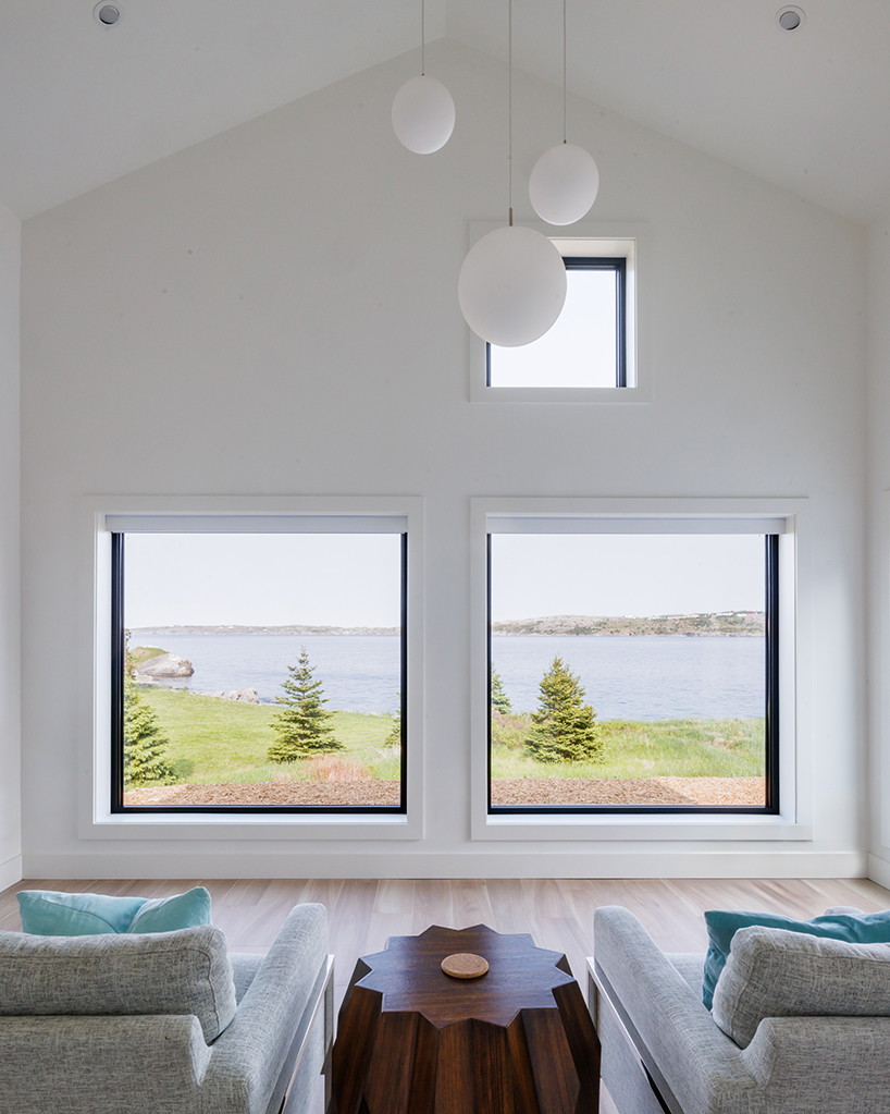 contrasting gable and mono-pitched metal roofs top wooden coley's point house in canada