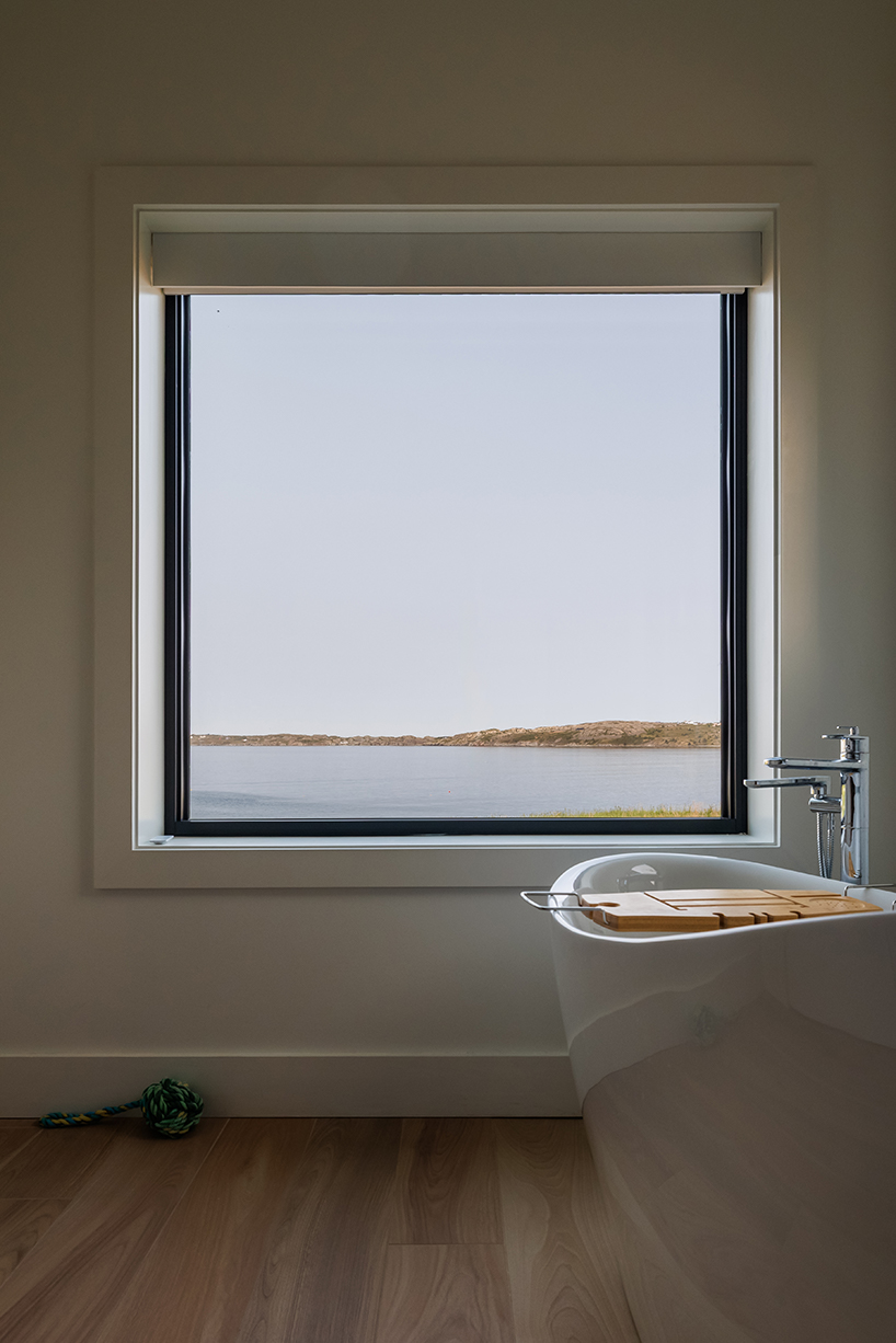 contrasting gable and mono-pitched metal roofs top wooden coley's point house in canada