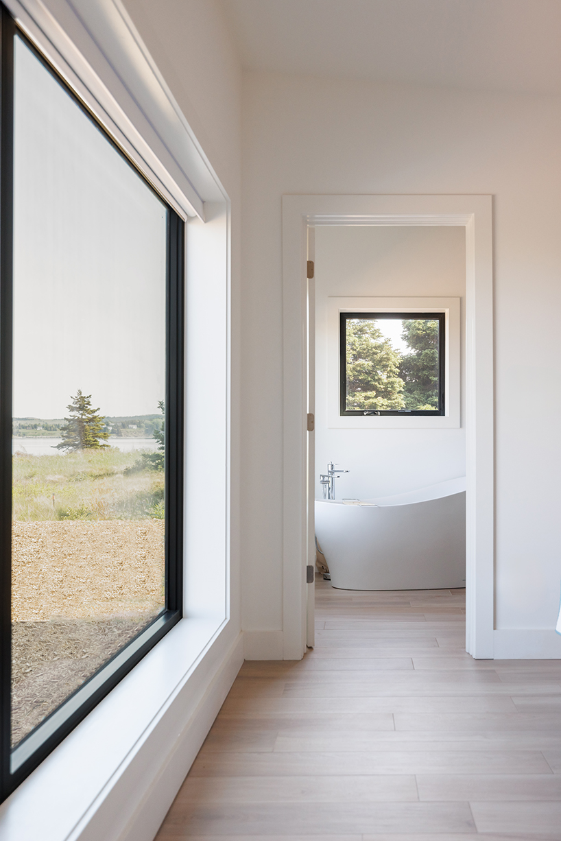 contrasting gable and mono-pitched metal roofs top wooden coley's point house in canada