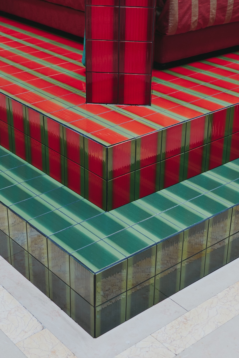 green and red ceramic tiles clad sculptural daybed by uchronia at hôtel plaza athénée, paris