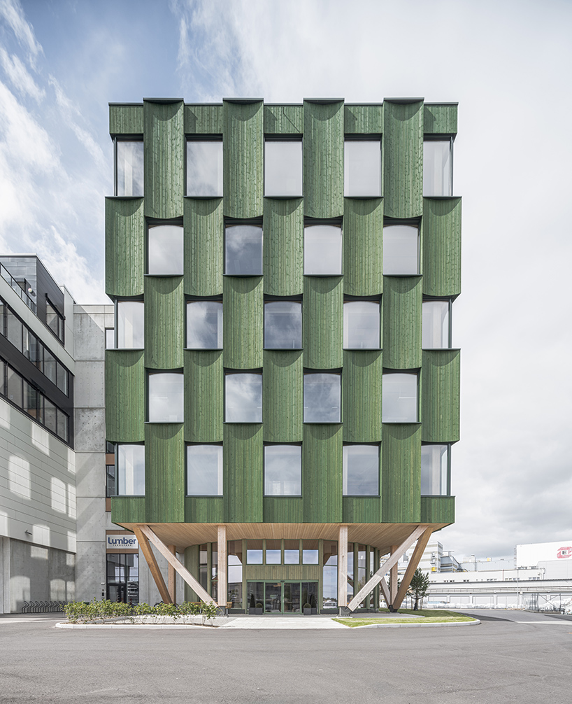 green timber curves sculpt rhythmic facade for office building in norway