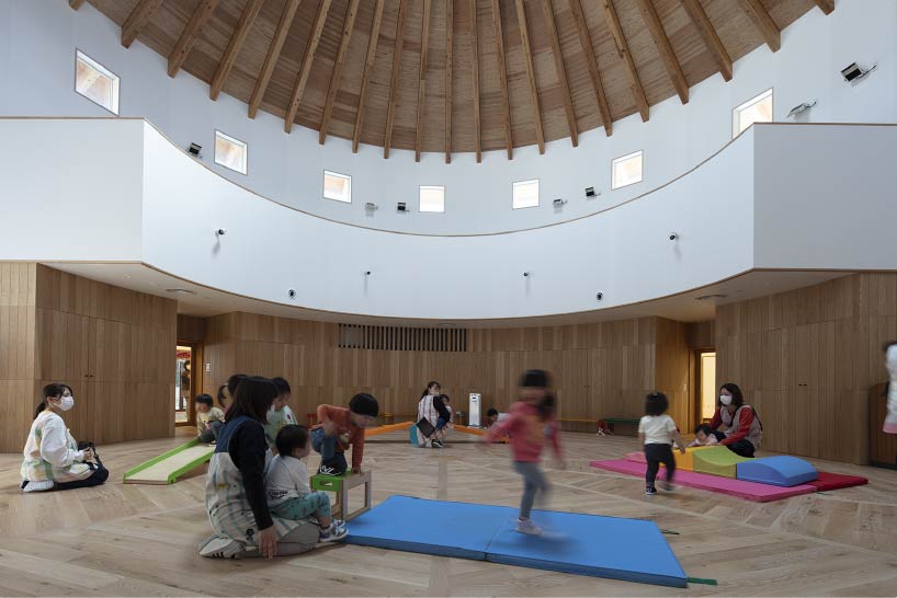 curved wooden frame shapes light-filled daycare center in japan encouraging playful learning