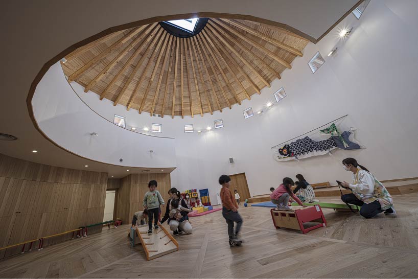 curved wooden frame shapes light-filled daycare center in japan encouraging playful learning