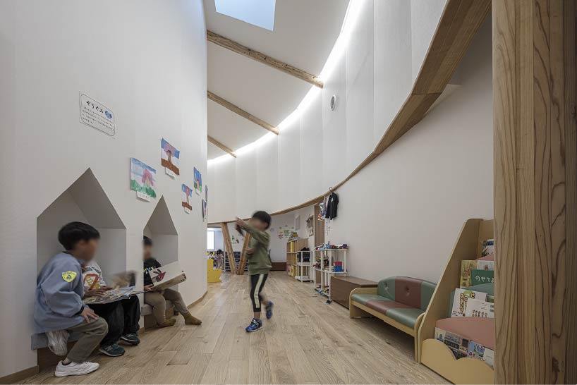 curved wooden frame shapes light-filled daycare center in japan encouraging playful learning