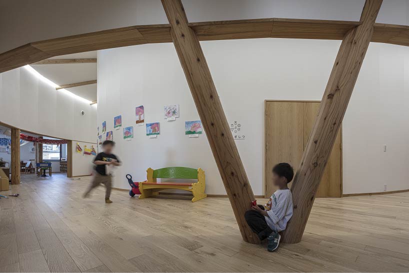 curved wooden frame shapes light-filled daycare center in japan encouraging playful learning