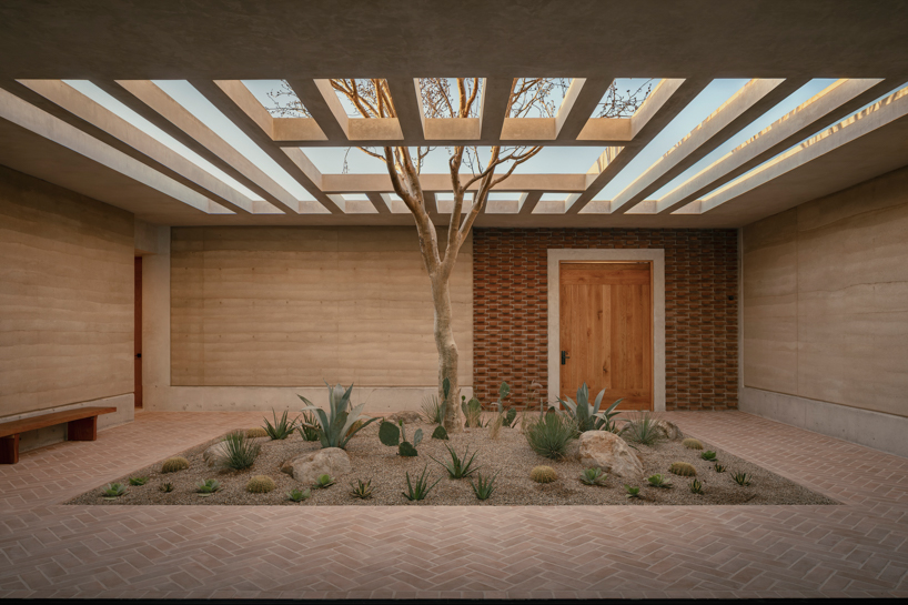 rammed-earth residence unfolds around central planted courtyard on mexico's coast