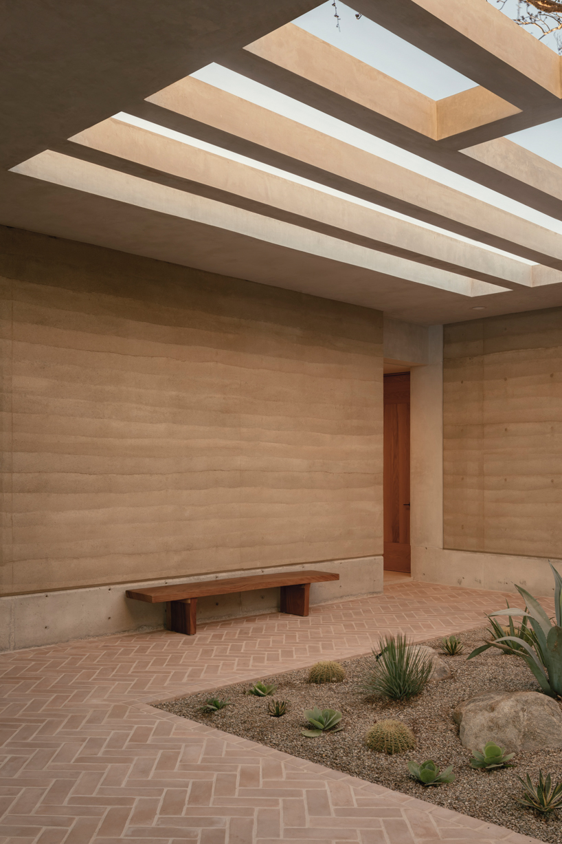 rammed-earth residence unfolds around central planted courtyard on mexico's coast