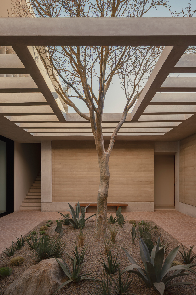 rammed-earth residence unfolds around central planted courtyard on mexico's coast