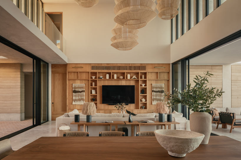 rammed-earth residence unfolds around central planted courtyard on mexico's coast