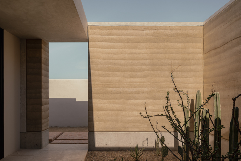 rammed-earth residence unfolds around central planted courtyard on mexico's coast