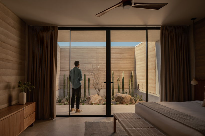 rammed-earth residence unfolds around central planted courtyard on mexico's coast