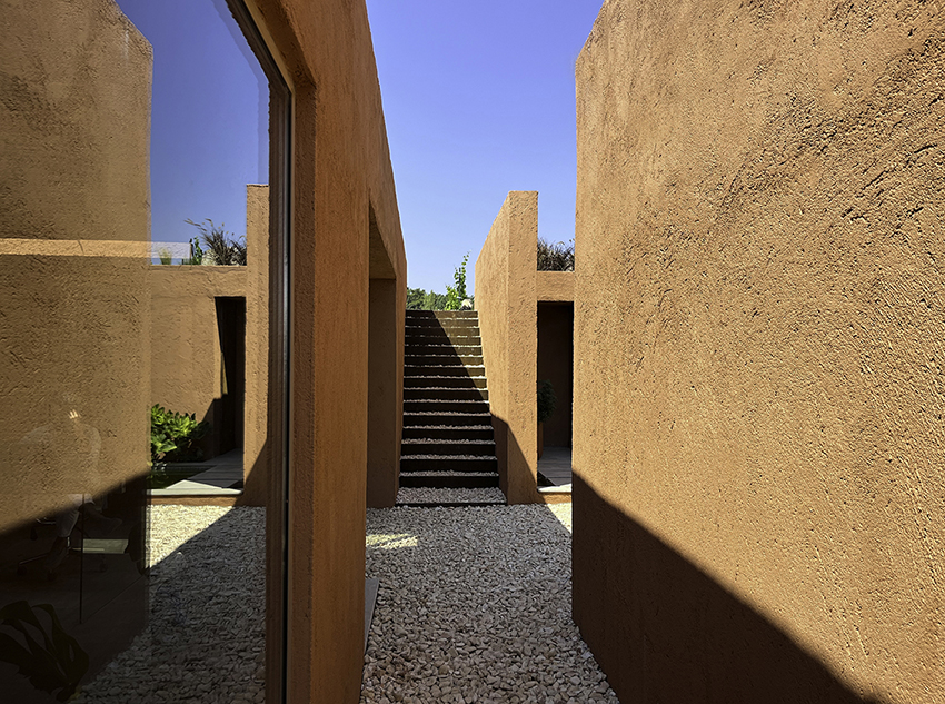 red earthen-plaster office's linear volumes trace grapevine rows in rural turkey