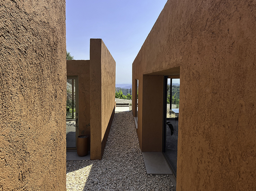 red earthen-plaster office's linear volumes trace grapevine rows in rural turkey