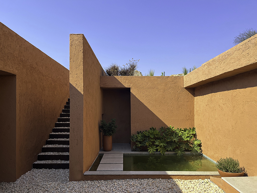 red earthen-plaster office's linear volumes trace grapevine rows in rural turkey