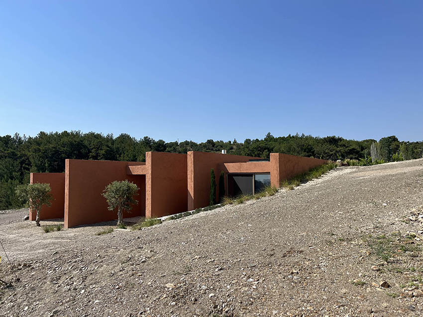 red earthen-plaster office's linear volumes trace grapevine rows in rural turkey