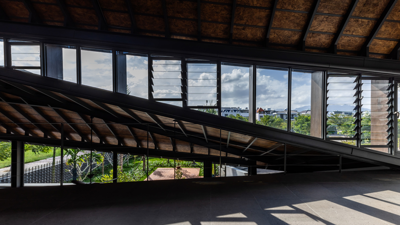 tent house expands under overlapping angular roof planes in vietnam