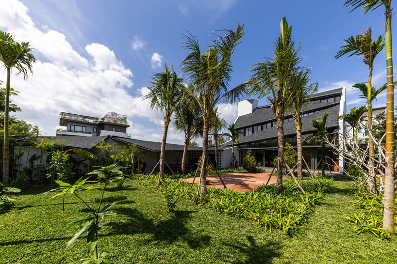 tent house expands under overlapping angular roof planes in vietnam