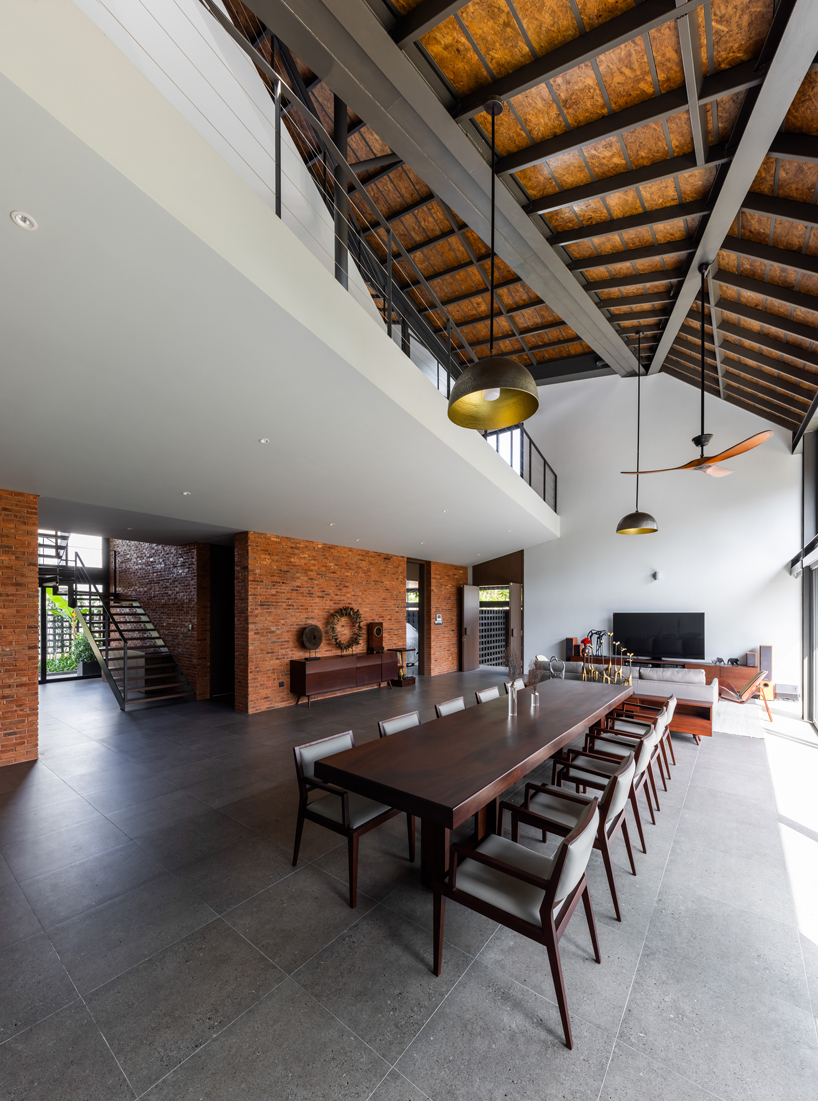 tent house expands under overlapping angular roof planes in vietnam