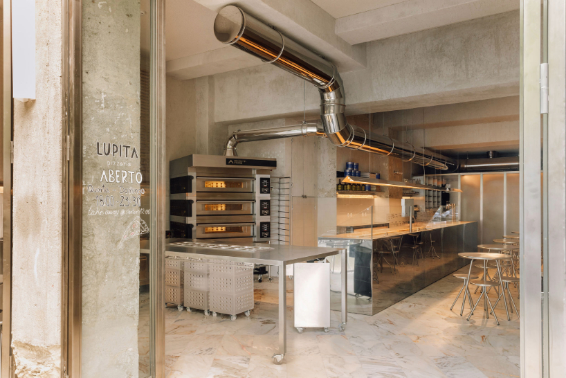 Los interiores de acero reflectante y las fachadas abiertas llevan la actividad callejera de Lisboa a la pizzería