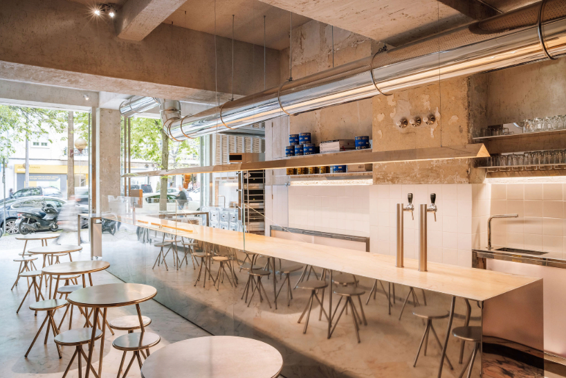 reflective steel interiors and open facade bring lisbon’s street activity into pizza restaurant